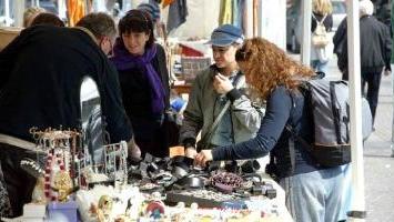 Un mercatino della scorsa estate e il manifesto degli eventi