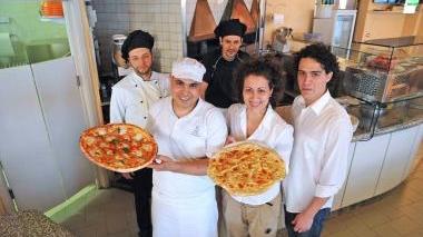 Sopra lo staff al completo della Tana del Coniglio a fianco acrobazia di Cristiano con la pizza