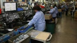 Operai all’interno della Piaggio mentre lavorano alla catena di montaggio