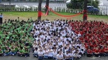 Tutti gli alunni della Collodi con le magliette bianche, rosse e verdi formano una grande bandiera tricolore