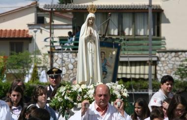 Una processione con la statua della Madonna di Fatima 