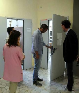 Una porta scassinata e, sopra, il sopralluogo 