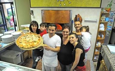 Le famiglie Spina e Fociniti al completo davanti a una pizza gigante del Grillo 