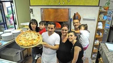 Le famiglie Spina e Fociniti al completo davanti a una pizza gigante del Grillo