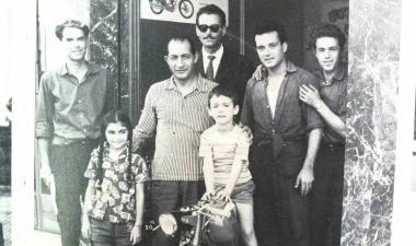 Una foto storica nel negozio sul lungarno: Carlo Papini è il bimbo sulla moto; a sinistra la sorella Elena e nel mezzo il mitico Gino Bartali All’estrema sinistra il babbo Giulio