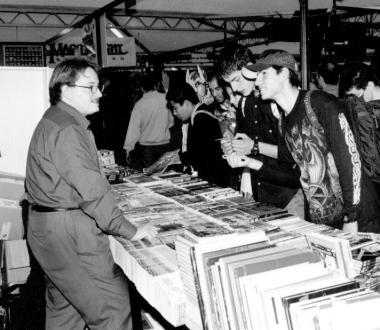 Uno stand di fumetti in unimmagine di repertorio. A destra Cosplay, giovani con i costumi dei protagonisti di fumetti e videogiochi 