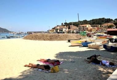 Turisti mentre prendono la tintarella a ridosso delle alghe 