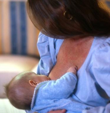 Una mamma mentre allatta il suo bambino       