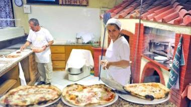 Si preparano le pizze da servire ai tavoli