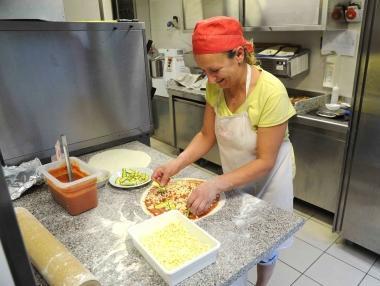 Si preparano le pizze da servire ai tavoli 