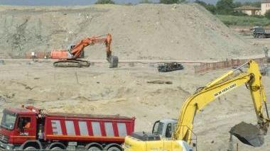 Camion al lavoro per portare via la sabbia scavata durante i lavori di costruzione del porto