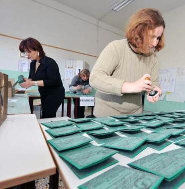 Un seggio elettorale, sopra uno slogan contro il nucleare