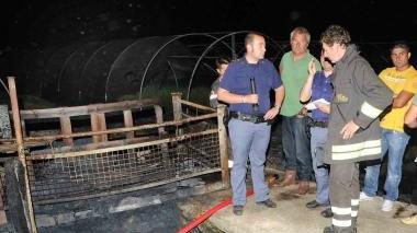 I poliziotti esaminano i resti delle due serre distrutte dalle fiamme in via di Ramini