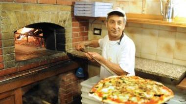 Giuseppe inforna una pizza gigante