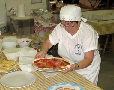 Una donna impegnata nella preparazione della pizza alla Festa dell’Unità di Lavaiano