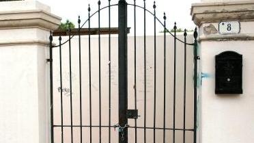 La facciata della villa sopra la spiaggia e il cancello chiuso