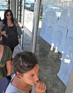 Una ragazza del liceo scientifico guarda i voti sulla bacheca 
