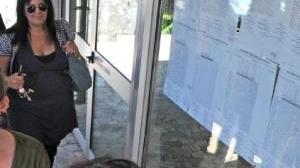 Una ragazza del liceo scientifico guarda i voti sulla bacheca