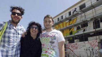 I giovani del gruppo Ada e, sullo sfondo, il murale