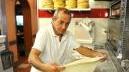 Giovanni al lavoro mentre prepara una pizza