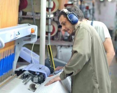 Un operaio al lavoro in unazienda tessile della Piana   