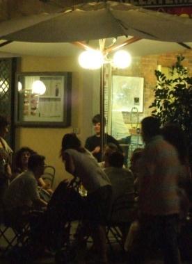 Giovani mentre bevono in un bar di sera  