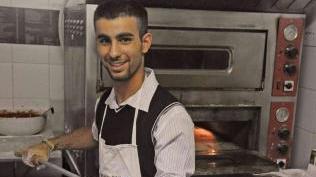 Il cuoco del Bastione prepara la pizza da mettere in forno