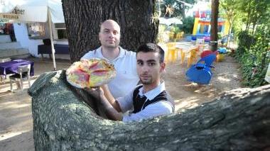 Il cuoco con una delle pizze e Daniele Perez, presidente di Amiamo Pistoia