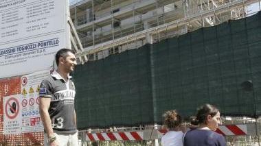 Una famiglia osserva da lontano il cantiere
