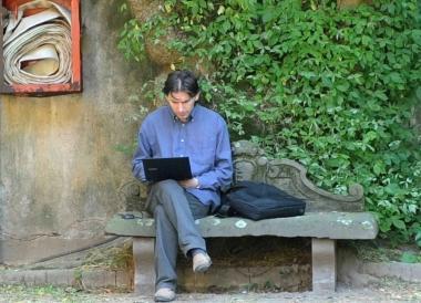 Un giovane naviga su Internet in unisola wifi in un parco          