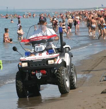 A destra una distesa di ombrelloni Sotto la polizia municipale sulla spiaggia 