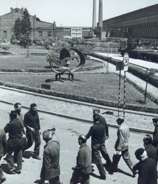 Lartista Beverly Pepper al lavoro nel&nbsp;62 nelle officine Italsider, a destra la sua scultura davanti alla fabbrica Sotto il vecchio altoforno e un reparto distrutto durante la guerra 