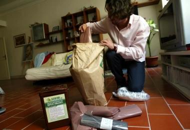 Un cittadino mentre suddivide i rifiuti negli appositi sacchetti per la raccolta porta a porta 