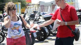 Il consigliere comunale Pdl Massimo Ciacchini durante il volantinaggio alla Rotonda A destra vigili che fanno multe sul viale Italia