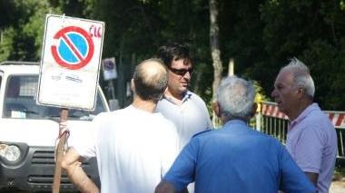 In alto il cartello di divieto di sosta sistemato dai vigili in via del Limoncino: il divieto resterà in vigore fino a settembre. Di lato le perplessità dei frontisti
