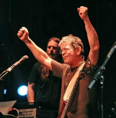 Lou Reed sul palco del Festival mentre saluta il pubblico e, a destra, con la sua band  