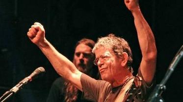 Lou Reed sul palco del Festival mentre saluta il pubblico e, a destra, con la sua band