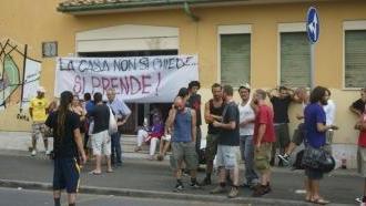 Lo striscione appeso alla porta: “La casa non si chiede, si prende”
