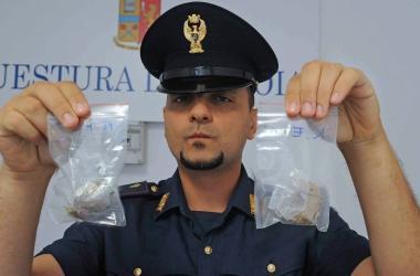 Un agente mostra due confezioni di cocaina sequestrate nelloperazione 