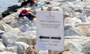 <b>IL CARTELLO.</b> Il divieto affisso sugli scogli alla foce del fiume Brugiano 