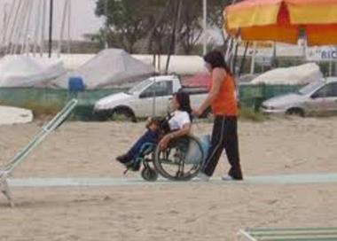 Un disabile in spiaggia: le difficolt&agrave; per laccesso a volte sono notevoli     