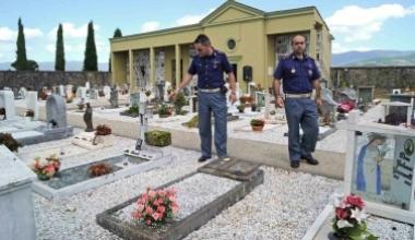 Gli agenti indicano le lapidi divelte dai vandali 