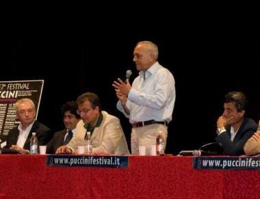 Il tavolo dei politici (in alto) ed il teatro in riva al lago 
