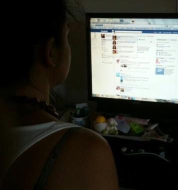 Una ragazza naviga sul sito di Facebook 