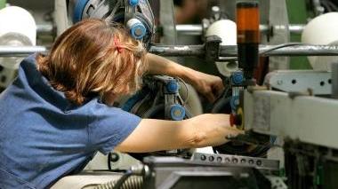 Un’operaia al lavoro in un’azienda tessile