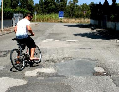 A destra e in basso buche su una strada della Mazzanta e dossi causati dalle radici  