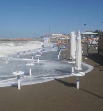 Ombrelloni chiusi sulla spiaggia mangiata dal mare 