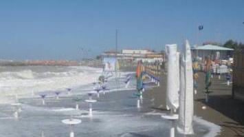 Ombrelloni chiusi sulla spiaggia mangiata dal mare