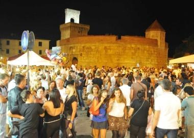 Turisti passeggiano in centro durante una serata estiva 