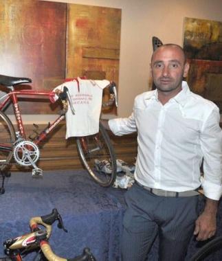 Paolo Bettini con la bici e alcuni piccoli atleti 